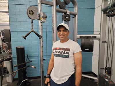 Member smiling by the cable workout machine.